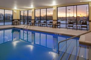 a swimming pool with tables and chairs in a building at Courtyard Kansas City Olathe in Olathe
