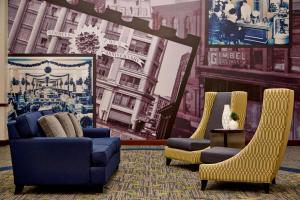 a living room with two blue chairs and a mural at Residence Inn Milwaukee Downtown in Milwaukee