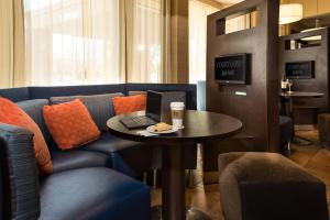 a room with a table with a laptop on a couch at Courtyard by Marriott Fort Collins in Fort Collins