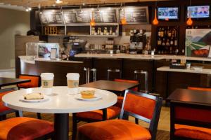 un ristorante con due tavoli e sedie e un bar di Courtyard by Marriott Fort Collins a Fort Collins