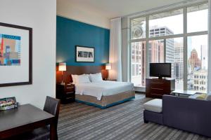 a hotel room with a bed and a large window at Residence Inn Milwaukee Downtown in Milwaukee