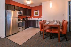 a kitchen with a table and a stainless steel refrigerator at Residence Inn Fairfax Merrifield in Merrifield