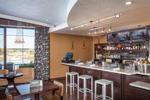 a restaurant with a bar with stools and tables at Courtyard Richland Columbia Point in Richland