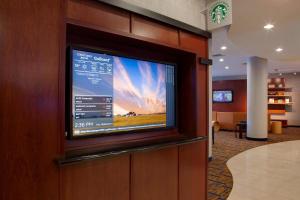 a flat screen tv on a wall in a lobby at Courtyard Des Moines Ankeny in Ankeny