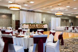 a banquet hall with white tables and white chairs at Courtyard Des Moines Ankeny in Ankeny