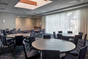 ハントバレーにあるCourtyard By Marriott Baltimore Hunt Valleyのテーブルと椅子、大きな窓が備わる客室です。