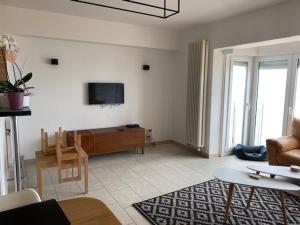 uma sala de estar com um sofá e uma televisão na parede em Appartement vue sur mer - Splendide localisation! em Koksijde