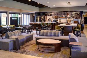 ein Restaurant mit Sofas und Tischen und eine Bar in der Unterkunft Courtyard Detroit Dearborn in Dearborn