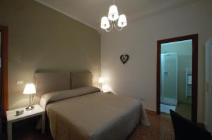 1 dormitorio con 1 cama, 2 lámparas y espejo en Giardino dei Frutti, en Bari