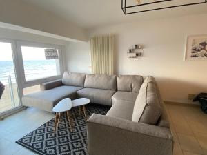 a living room with a couch and a table at Appartement vue sur mer - Splendide localisation! in Sint-Idesbald