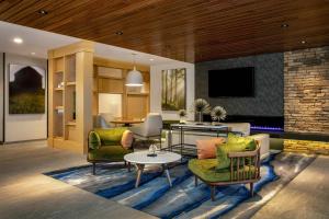 uma sala de estar com cadeiras verdes e uma mesa em Fairfield by Marriott Inn & Suites Harrisburg West/Mechanicsburg em Mechanicsburg