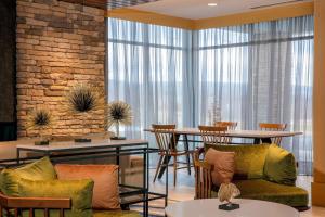 a lobby with chairs and tables and a brick wall at Fairfield by Marriott Inn & Suites Harrisburg West/Mechanicsburg in Mechanicsburg