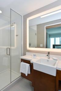 a bathroom with a sink and a mirror at SpringHill Suites by Marriott Charlotte City Center in Charlotte