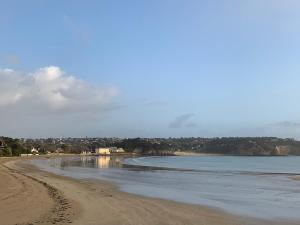 a beach with footprints in the sand and water at L améthystes in Crozon