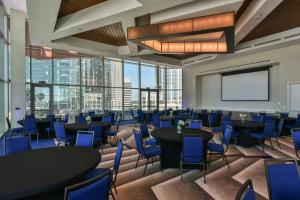 a conference room with tables and chairs and a projection screen at SpringHill Suites by Marriott Charlotte City Center in Charlotte