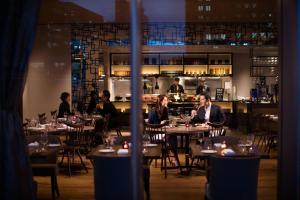 a group of people sitting at tables in a restaurant at Courtyard by Marriott Shin-Osaka Station in Osaka
