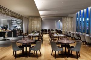 a restaurant with tables and chairs and a bar at Courtyard by Marriott Shin-Osaka Station in Osaka