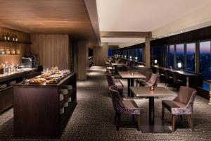 a restaurant with tables and chairs with a view at Courtyard by Marriott Shin-Osaka Station in Osaka