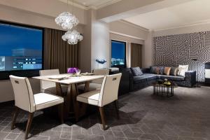 a dining room and living room with a table and chairs at Courtyard by Marriott Shin-Osaka Station in Osaka