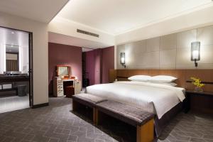 a bedroom with a large bed and a bathroom at Courtyard by Marriott Shin-Osaka Station in Osaka