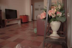 a vase with flowers on a shelf in a living room at A Nespulara in Galati Marina