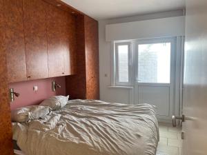 um quarto com uma cama, uma janela e uma porta em Appartement vue sur mer - Splendide localisation! em Koksijde