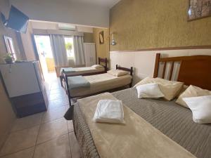 Habitación de hotel con 3 camas y pantalla de proyección en Pousada Do Pancho en Maricá