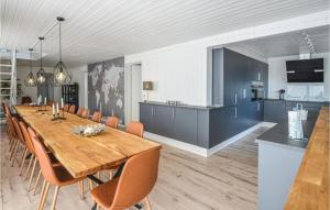 エーベルトフトにあるStunning Home In Ebeltoft With Sauna, Wifi And Indoor Swimming Poolのダイニングルーム(長い木製テーブル、椅子付)