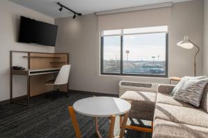 TownePlace Suites by Marriott Sidney في Sidney: غرفة معيشة مع أريكة وطاولة ومكتب