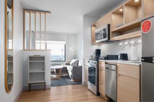 TownePlace Suites by Marriott Sidney في Sidney: مطبخ وغرفة معيشة مع طاولة وكراسي