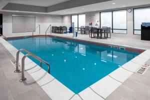 a large swimming pool with blue water in a building at TownePlace Suites by Marriott Sidney in Sidney