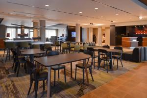 a restaurant with tables and chairs and a bar at Courtyard by Marriott St. Louis St. Peters in Saint Peters
