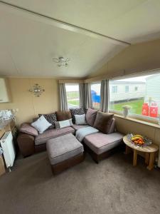 a living room with a couch and a table at Chalet 40, Cleethorpes in Humberston