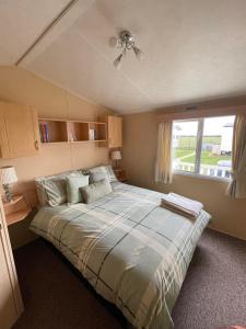 - une chambre avec un grand lit et un ventilateur de plafond dans l'établissement Chalet 40, Cleethorpes, à Humberston