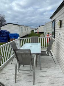 a patio with a table and chairs on a deck at Chalet 40, Cleethorpes in Humberston