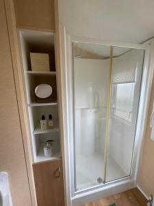 a shower in a bathroom with a glass door at Chalet 40, Cleethorpes in Humberston