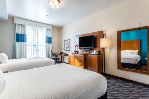 a hotel room with two beds and a mirror at Fairfield Inn & Suites by Marriott Alamogordo in Alamogordo