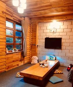 ein Wohnzimmer mit einem Tisch und einem Flachbild-TV in der Unterkunft Simplewoods Homestay in Da Lat in Da Lat