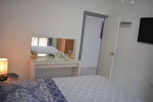 a bedroom with a bed and a mirror at Torri apartments - 3 mins walk to beach in Torrevieja +26 photos
