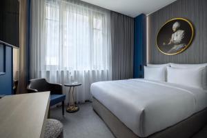 a hotel room with a large bed and a window at Hotel Luc, Autograph Collection in Berlin