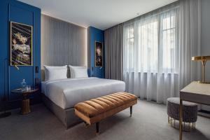 Schlafzimmer mit einem großen weißen Bett und blauen Wänden in der Unterkunft Hotel Luc, Autograph Collection in Berlin