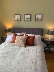 um quarto com uma cama com almofadas e 2 candeeiros em Private Entranced Guest suite/Kitchenette/Patio em Balderton