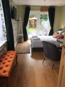 um quarto com uma cama e um sofá em Private Entranced Guest suite/Kitchenette/Patio em Balderton