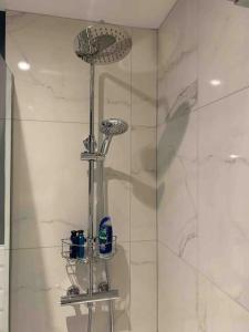a shower stall with a shower head and a shower at Private Entranced Guest suite/Kitchenette/Patio in Balderton