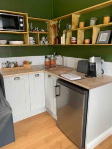 a kitchen with white cabinets and a counter top at Private Entranced Guest suite/Kitchenette/Patio in Balderton