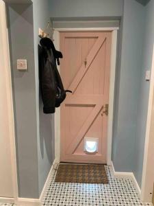 a pink door with a toilet in a hallway at Private Entranced Guest suite/Kitchenette/Patio in Balderton