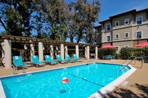 TownePlace Suites San Jose Cupertino في سان خوسيه: مسبح وكراسي وفندق