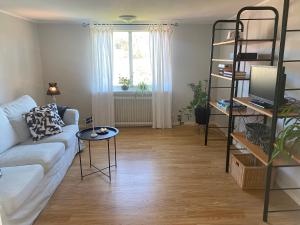 uma sala de estar com um sofá e uma mesa em Persgård lägenhet övervåning em Kungsbacka