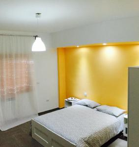 a bedroom with a bed and a yellow wall at B&B Stefyld in Paola