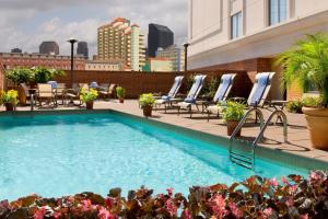 a swimming pool on the roof of a building with chairs at New Orleans Marriott Warehouse Arts District in New Orleans